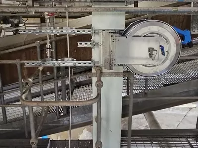 High-pressure stainless steel hose reel and trigger gun mounted to a support column as part of the washdown system at an industrial site in Burton.